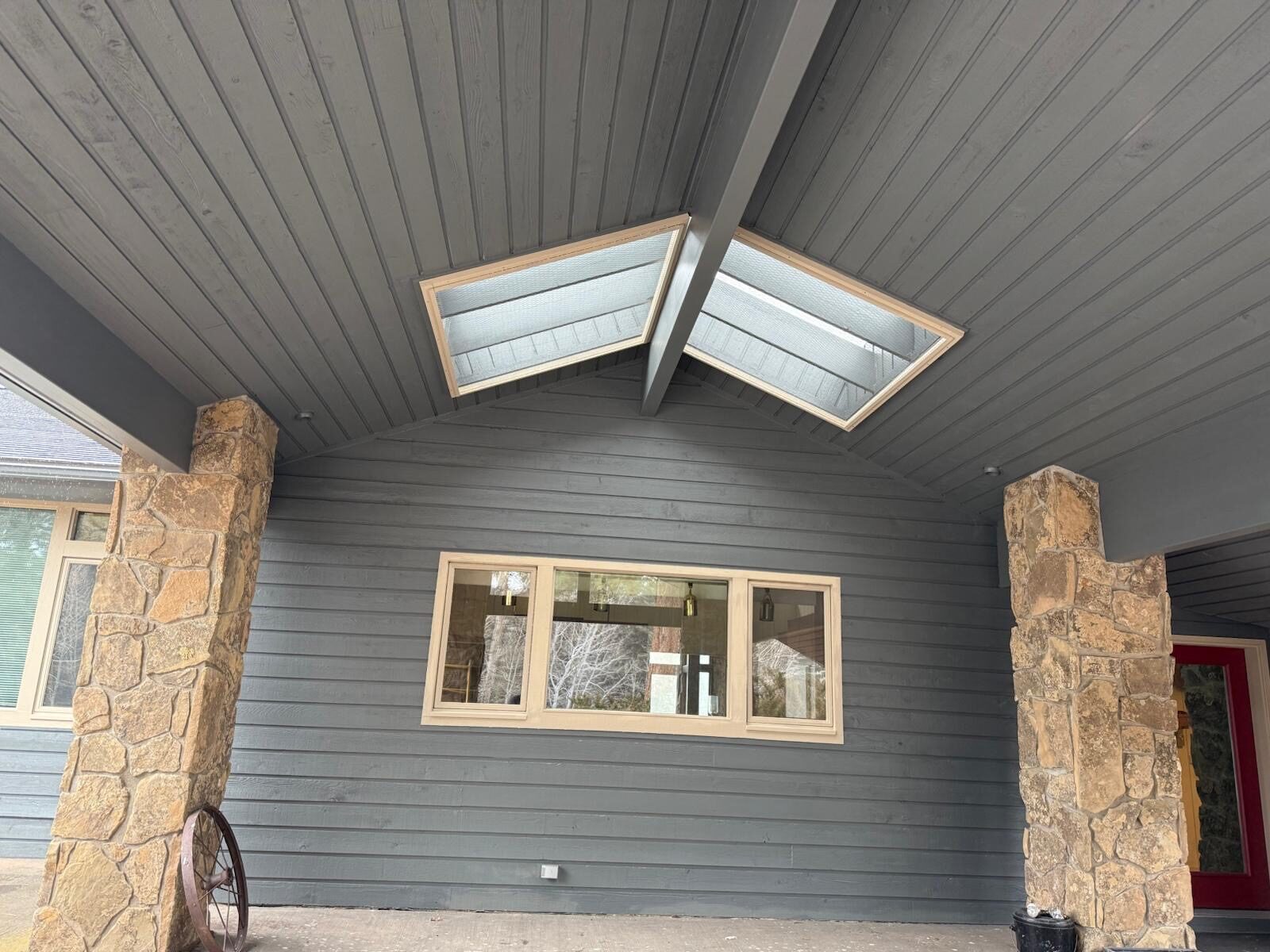 Covered entry with stone columns and new siding